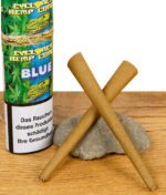 Nahaufnahme der Cyclones Hemp Blunts Blue vor Dose auf Holz, beide Cones über Kreuz gelegt