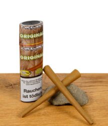 Zwei vorgerollte Cyclones Blunts Original mit braunem Cone und Filter liegen vor der Verpackung auf einem Holzuntergrund mit Stein – Ready-to-fill Blunts im King Size Format.