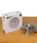 Fine (#2)  Mahlplatte der Flower Mill 2,0" Serie vor ihrer Verpackung auf Holz positioniert.