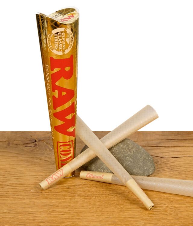 Drei RAW Ethereal Cones mit goldener Verpackung auf einem Holzuntergrund, zwei auf einem Stein liegend.