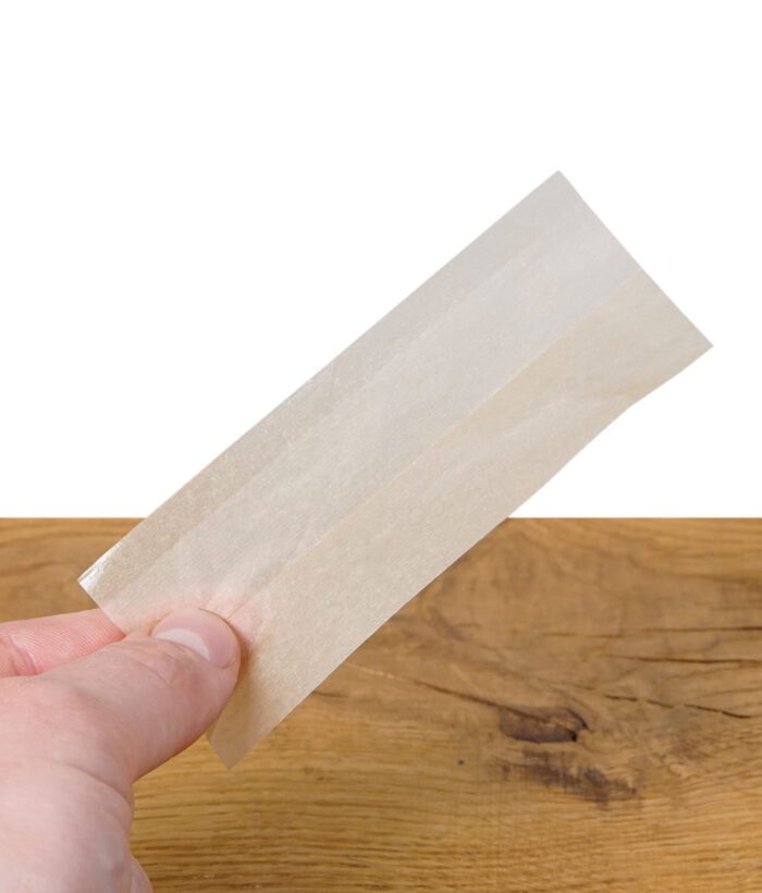 Einzelnes Mascotte Brown Slim King Size Paper wird von einer Hand gehalten.