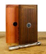 2 Dynavap Starterboxen aus Wallnuss und Zedernholz stehen nebeneinander auf einem Holzuntergrund.