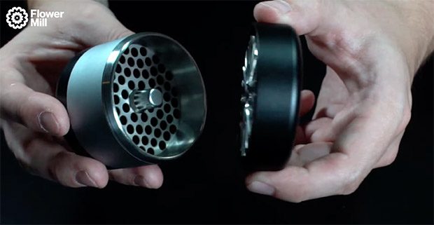 Geöffneter Flower Mill Grinder aus Edelstahl mit innovativer Mahltechnik in zwei Händen gehalten.