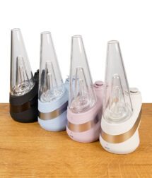 Vier Puffco New Peak Vaporizers in den Farben Cloud, Onyx, Bliss und Sky nebeneinander auf Holz.