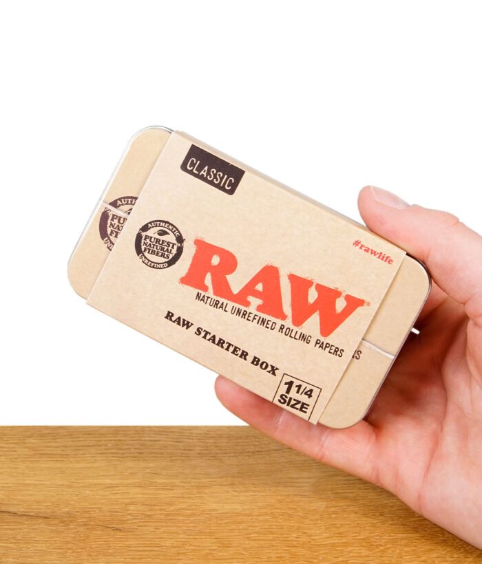 Hand hält die RAW Starter Box Classic in der Größe 1¼, beige mit rotem Logo