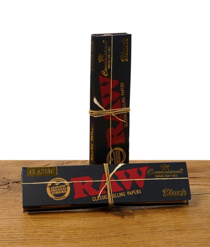 Zwei RAW Black Connoisseur Paper Packs mit Hanfband umwickelt auf Holzfläche