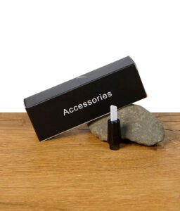 Verpackung und Ersatz-Heizspitze für das Black Leaf Hot Knife auf Holzuntergrund mit Stein.