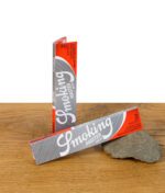 Smoking Master King Size Slim Paper ungeöffnet, zwei Packungen auf Holzfläche