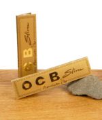Zwei geschlossene OCB Premium Paper Gold Oro Slim Packungen in Goldoptik auf Holztisch