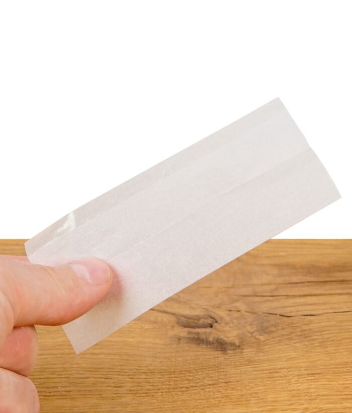 Hand hält ein einzelnes OCB Premium Oro Slim Paper zur Veranschaulichung der Transparenz