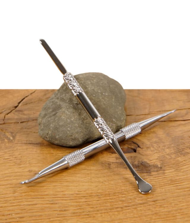 Zwei Black Leaf Dabtools gekreuzt auf Holzoberfläche mit Stein – hochwertiges Zubehör für Dabbing