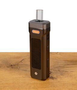 Black Leaf Cigar X1 Vaporizer stehend auf Holztisch, mit Glasmundstück und seitlichen Bedientasten.