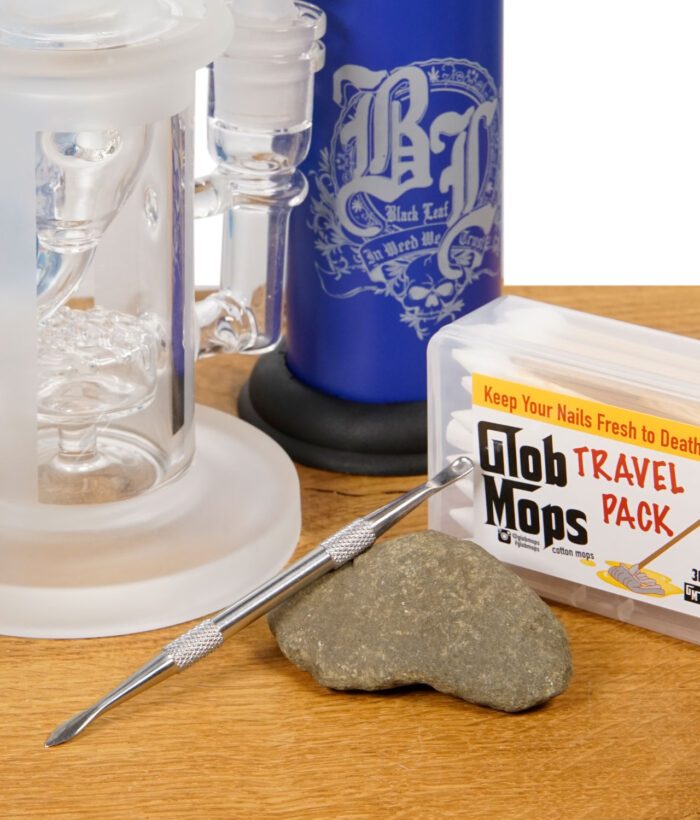 Dabbing-Zubehör mit Dabber, Glob Mops, Gasbrenner und Glasbubbler auf Holzoberfläche
