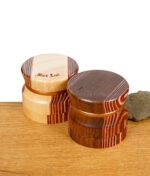 Zwei Black Leaf Grinder aus Holz mit Aluminiumkern auf einem Holztisch
