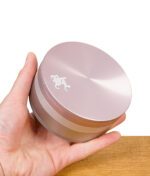 Geschlossener Grinder in Roségoldoptik wird in einer Hand gehalten