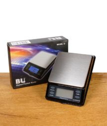 Digitale Taschenwaage mit Edelstahl-Wiegefläche neben der Produktverpackung