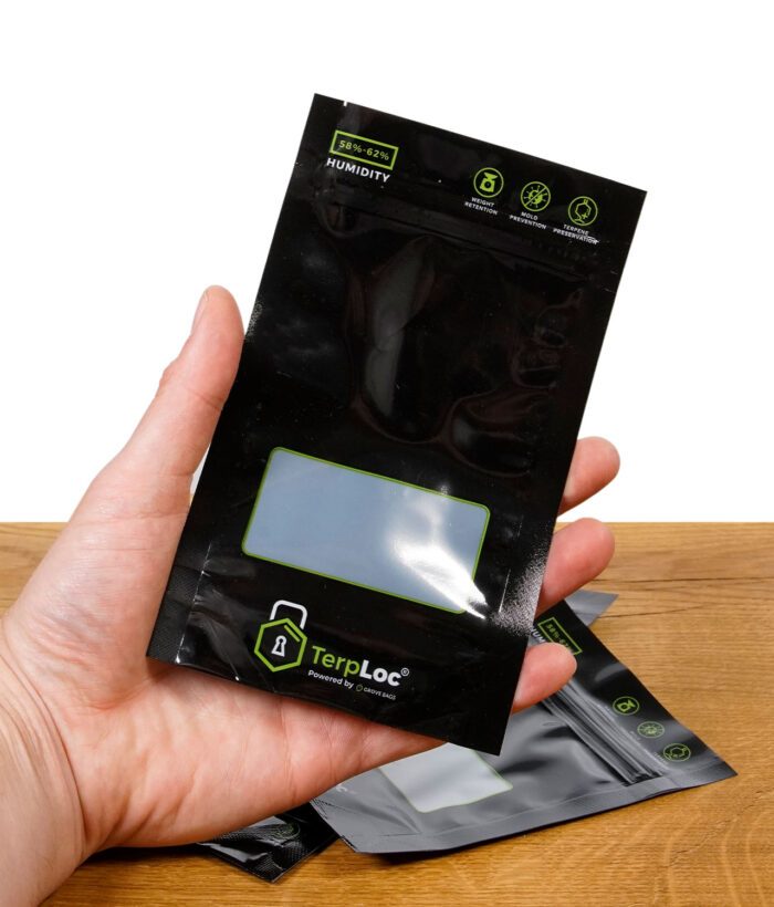 Schwarzer Grove Bags TerpLoc Beutel in Hand gehalten, im Vordergrund Sichtfenster und TerpLoc-Logo