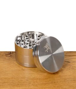 Geöffneter Black Leaf Grinder aus Edelstahl, Deckel mit Logo liegt schräg an der Seite