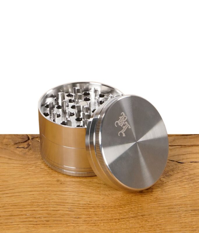 Geöffneter Black Leaf Grinder aus Edelstahl, Deckel mit Logo liegt schräg an der Seite