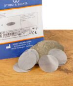 Rückseite der Verpackung mit fünf entnommenen Rundsieben auf einem Stein