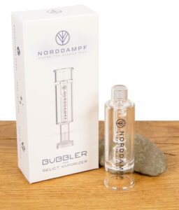 Norddampf Glasbubbler für Relict Vaporizer mit Produktverpackung im Hintergrund