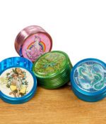 Vier bunte Black Leaf Grinder mit verschiedenen Motiven: Einhorn, Drache, Leafly & Affe mit Bong