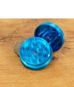 Geöffneter blauer Black Leaf Grinder mit scharfen Zähnen auf Holztisch