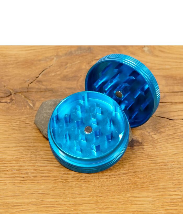 Geöffneter blauer Black Leaf Grinder mit scharfen Zähnen auf Holztisch