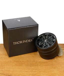 Thorinder Grinder neben schwarzer Verpackung mit silberner Aufschrift