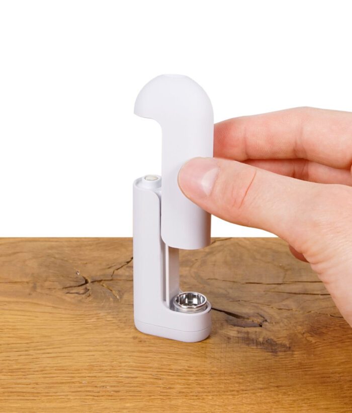 Eine Hand führt die obere Abdeckung des Vaporizers präzise in das Gehäuse ein – gut sichtbar ist die magnetische Steckverbindung.