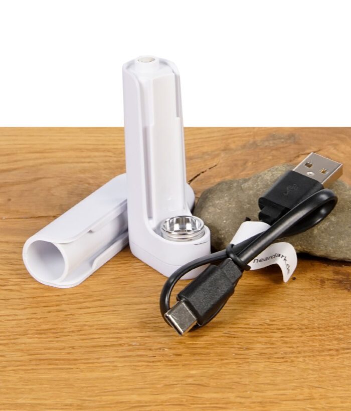 Der zerlegte Vaporizer zeigt seine beiden Hauptteile neben einem mitgelieferten USB-C-Ladekabel auf einem Holztisch.