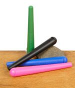 Vier THE BULLDOG Jointtubes in Grün, Schwarz, Blau und Pink auf einem Stein liegend, auf Holzoberfläche.