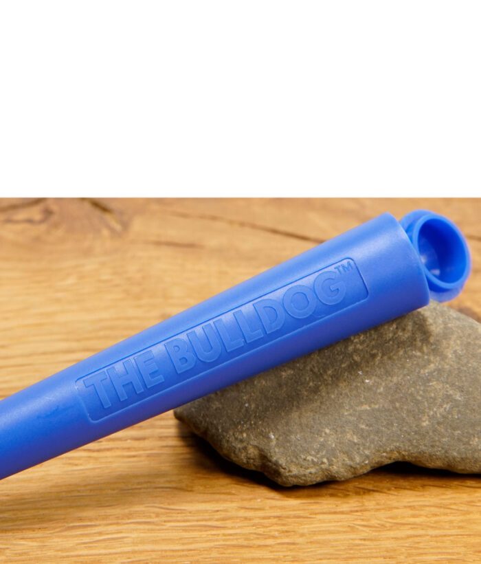 Nahaufnahme eines blauen THE BULLDOG Jointtubes mit Logo-Prägung auf Holzuntergrund.
