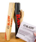RAW Huge Roller neben geöffneter Verpackung und gedruckter Anleitung, gehalten von einer Holzhand.