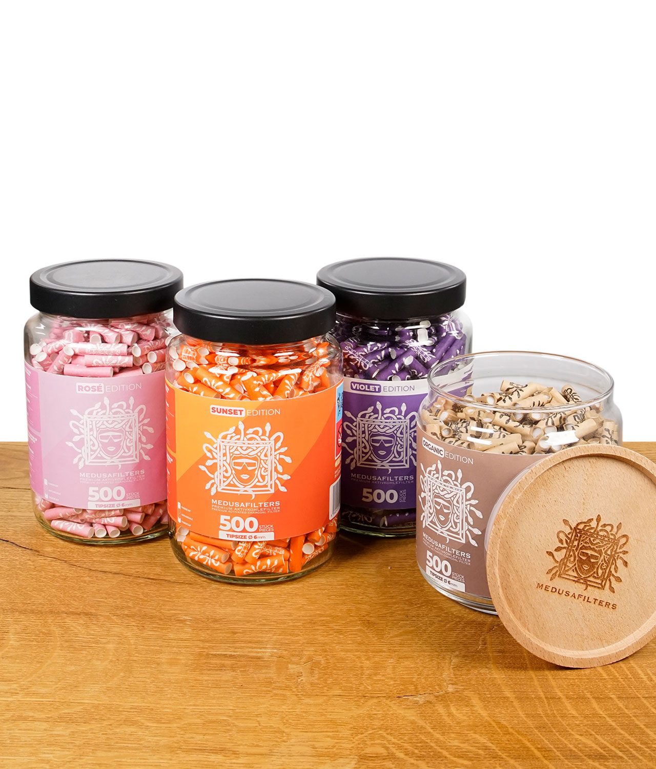medusafilters-500er-glas-jpg Medusafilters Gläser der Rosé, Sunset, Violet und Organic Edition mit abgenommenem Holzdeckel der Organic Edition im Vordergrund.