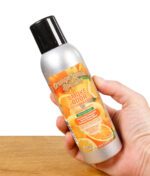 Hand hält Smoke Odor Exterminator Spray Orange Lemon Splash mit Blick auf das Etikett