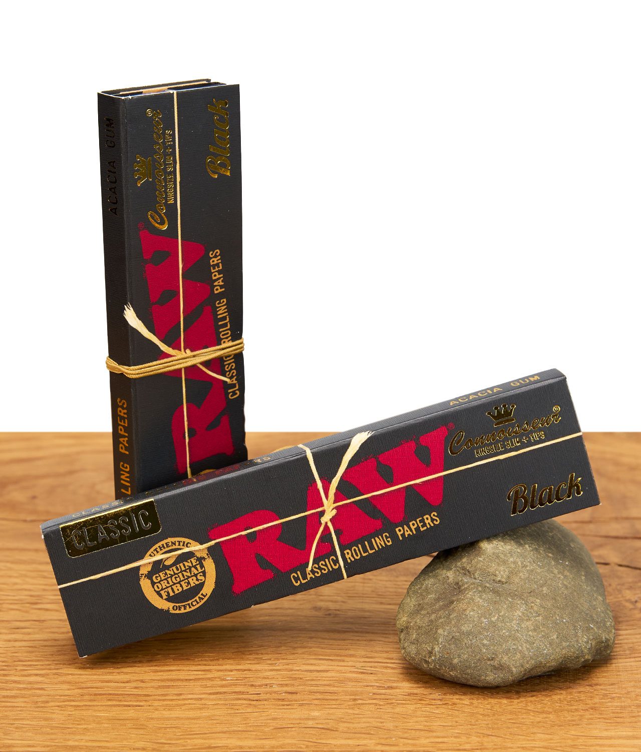 raw-black-connisseur-paper-jpg Zwei Packungen RAW Black Connoisseur Papers mit goldener Kordel auf Holztisch arrangiert.