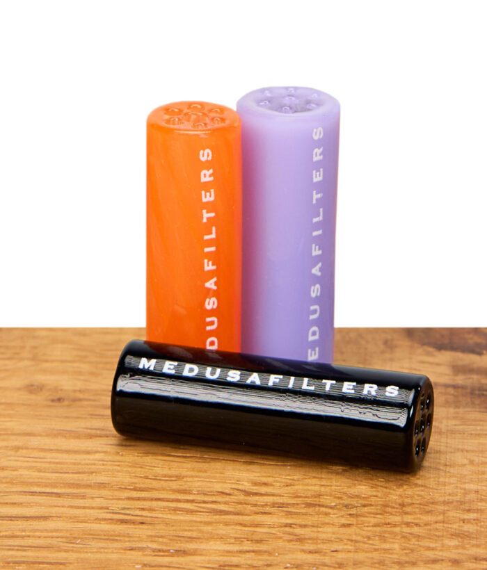 Medusafilters Glasfilter in Sunset, Violet und Schwarz stehend und liegend auf Holzuntergrund