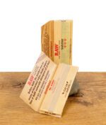 Geöffnete Packung RAW Classic Rolling Papers 20th Anniversary mit sichtbaren Papers und Innendruck