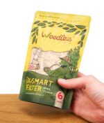 Gelber Standbeutel Weedlez Smart Filter Phil Trino 6 mm, gehalten von einer Hand, mit durchsichtigem Sichtfenster und Comic-Illustrationen.