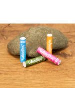 Vier bunte Weedlez Smart Filter in Blau, Pink, Orange und Grün nebeneinander vor einem Stein