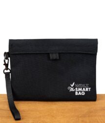 Geruchssichere Weedlez The Smart Bag in Schwarz mit Logoaufdruck auf einem Holztisch.