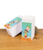 Zwei Blöcke Jilter Filtertips Jiltip M mit farbigem Comic-Covermotiv auf Holzuntergrund vor weißem Hintergrund