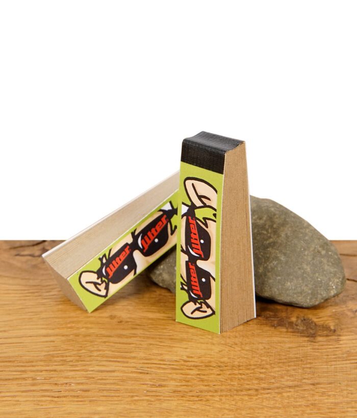Zwei stehende Jilter Jiltips S ungebleicht mit auffälligem Design, auf Holz mit Stein im Hintergrund