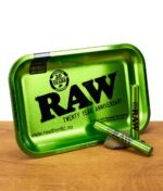 Grüne RAW Rolling Tray 20th Anniversary Edition mit zwei passenden Aluminium Jointtubes auf Holzuntergrund.