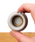 Ein MouthPeace Filter ist in ein passendes Silikon-Mundstück eingesetzt und wird mit zwei Fingern gehalten.