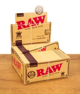 Geöffnete Box mit 50 Packungen RAW Classic King Size Slim Papers als Verkaufsdisplay
