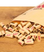 RAW Wide Tips 180er lose auf dem Tisch vor geöffneter Verpackung verteilt.