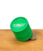 Grüner Santa Cruz Hemp Shredder Grinder, schräg auf einem Stein stehend