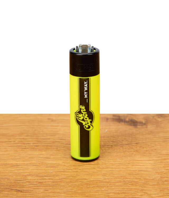 Clipper Feuerzeug mit Al Capone Logo in Neon-Gelb auf Holzuntergrund